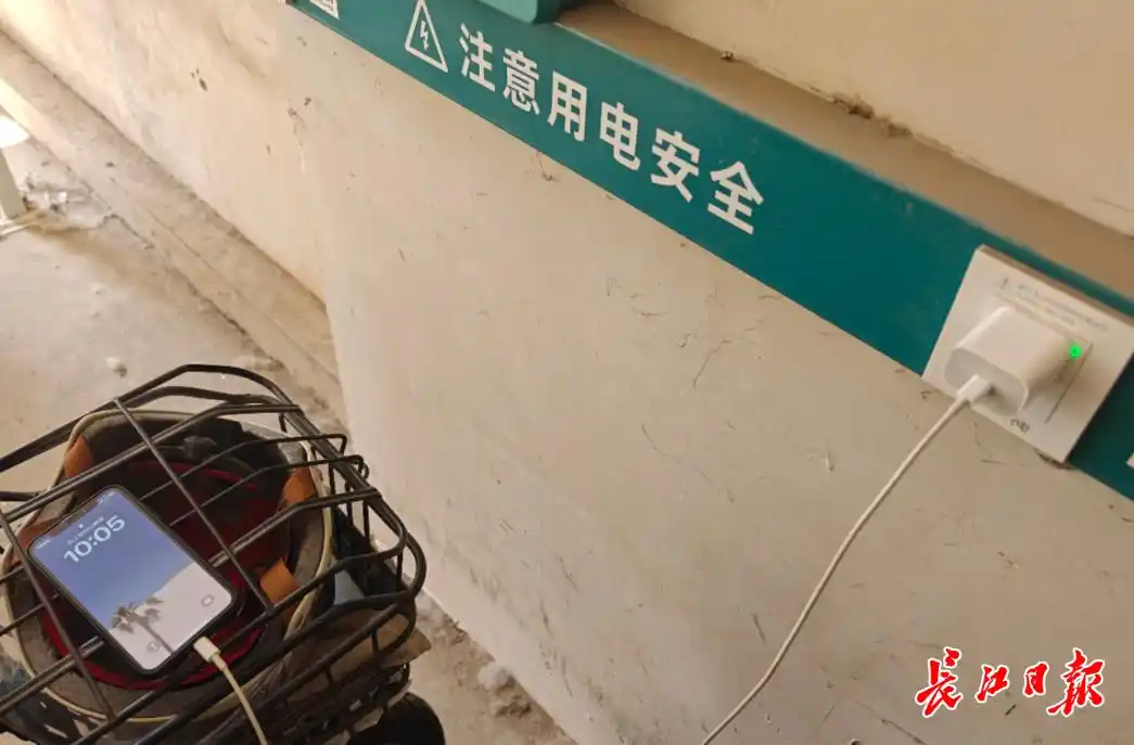 男子手机没电扫电动车充电桩充电_记者实测电动车充电桩充电费用低_电动汽车充电器